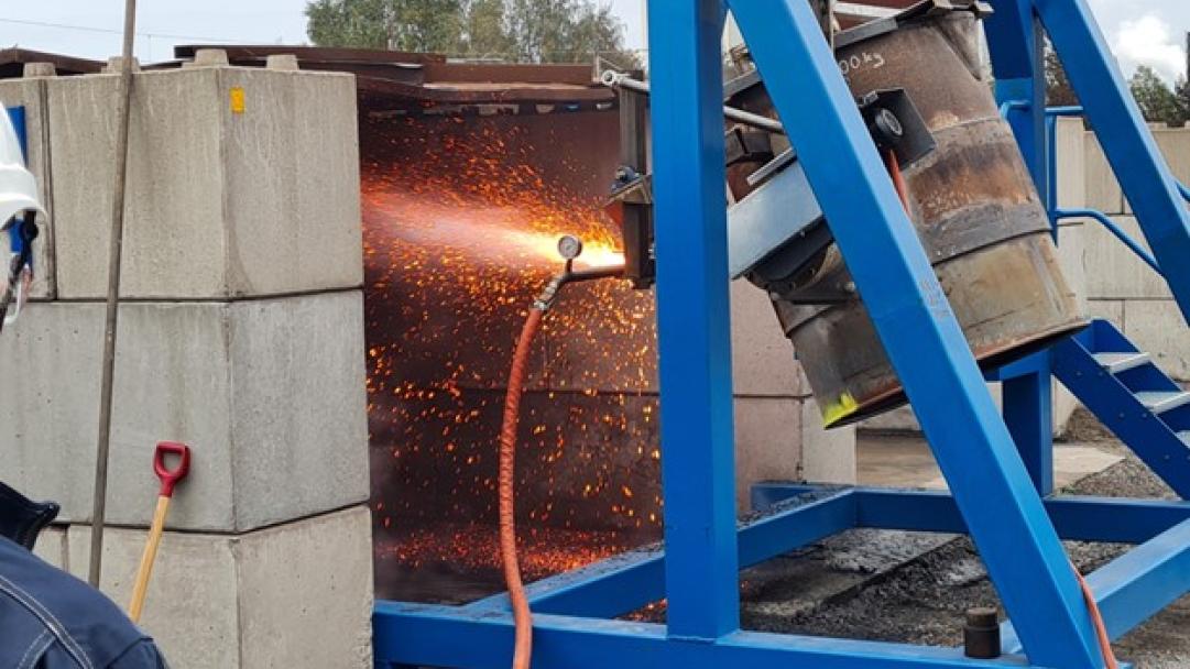 Granulering pågår. Slaggen slungas med hjälp av vattenstrålar in i ett betongfack för senare uppsamling.